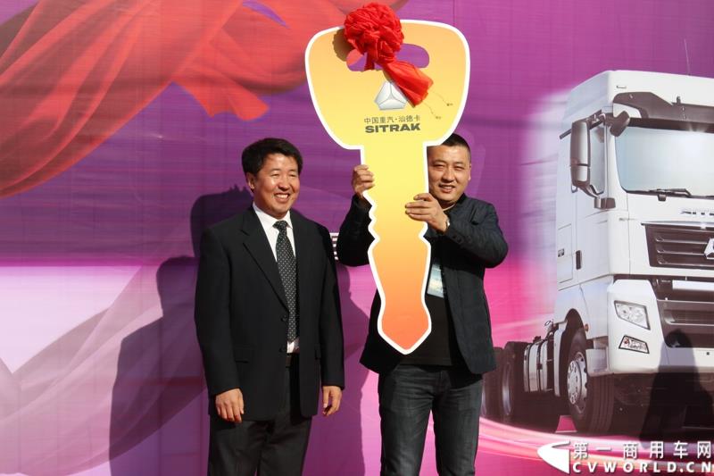 2014年12月29日，中国重汽SITRAK·汕德卡2014体验式互动路演收官站在济南完美上演。图为中国重汽（香港）有限公司商用车销售部总经理刘正涛将金钥匙交给第1000位汕德卡用户